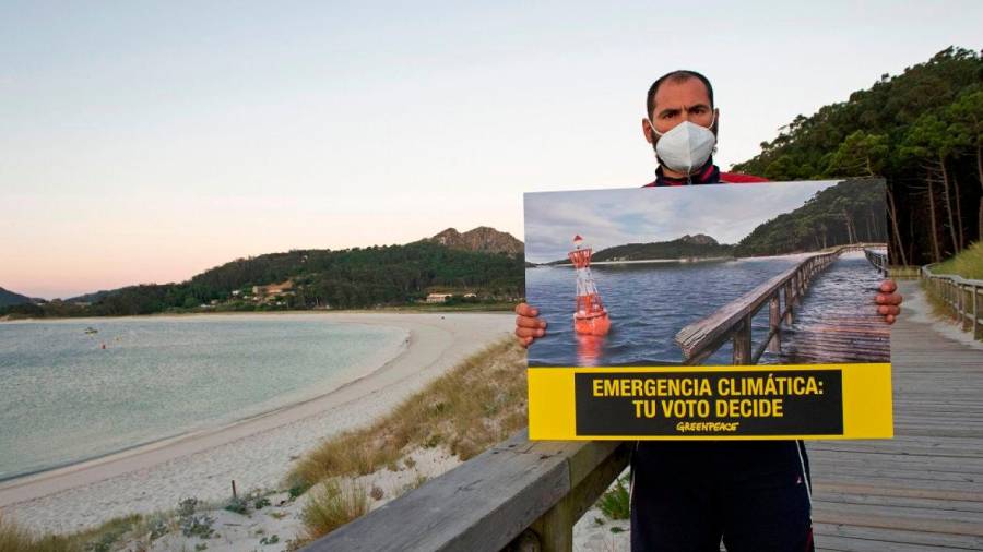 Un activista de Greenpeace sosteniendo el lema de su campaña. Foto: Greenpeace.