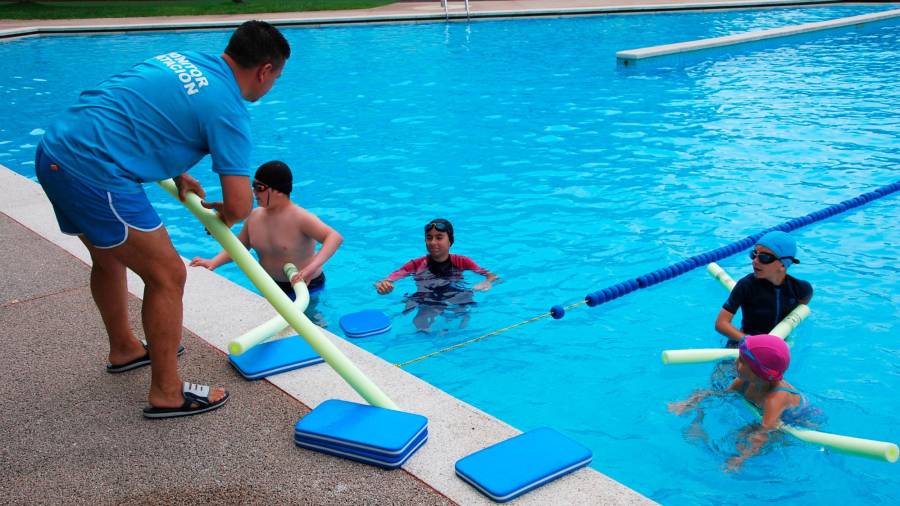 Nenos e monitor nunha anterior edición dos curso de natación nas piscinas amesás. Foto: CA