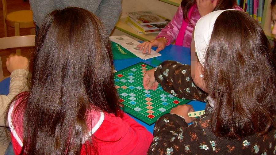 Rapazas utilizando un xogo de mesa como os que divulga Xandobela en Apego. Foto: Xandobela