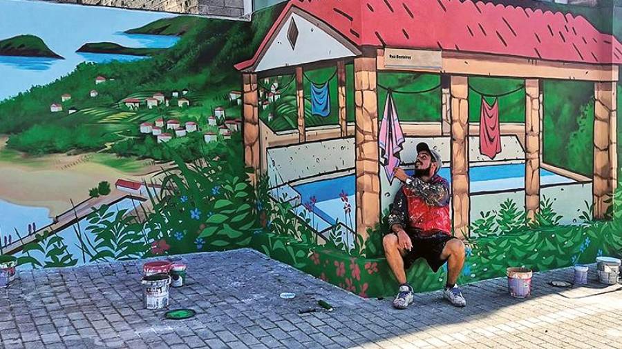 LAVADERO. El artista Doctor Toy posa junto al mural que hizo en Noia, en el que pintó un lavadero. Foto: Vella Escola