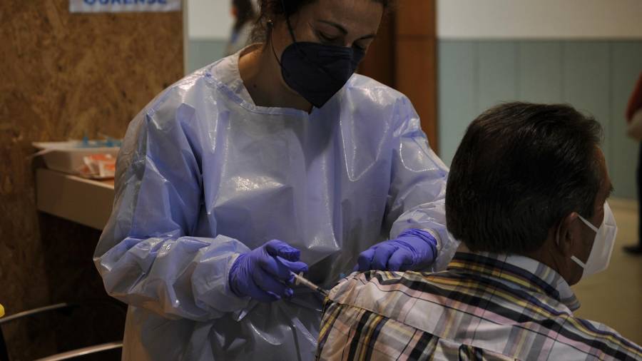 En la foto de archivo, una sanitaria inyecta a un paciente la primera dosis de la vacuna AstraZeneca en el recinto de Expourense. ROSA VEIGA / EUROPA PRESS