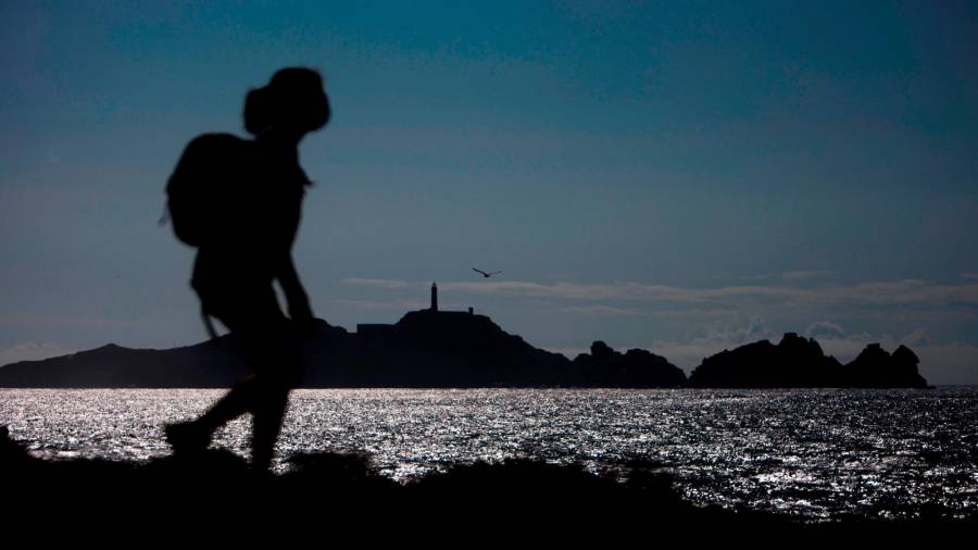 Silueta de un senderista recorriendo el Camiño dos Faros a su paso por la costa de Camariñá. Foto: Cabalar