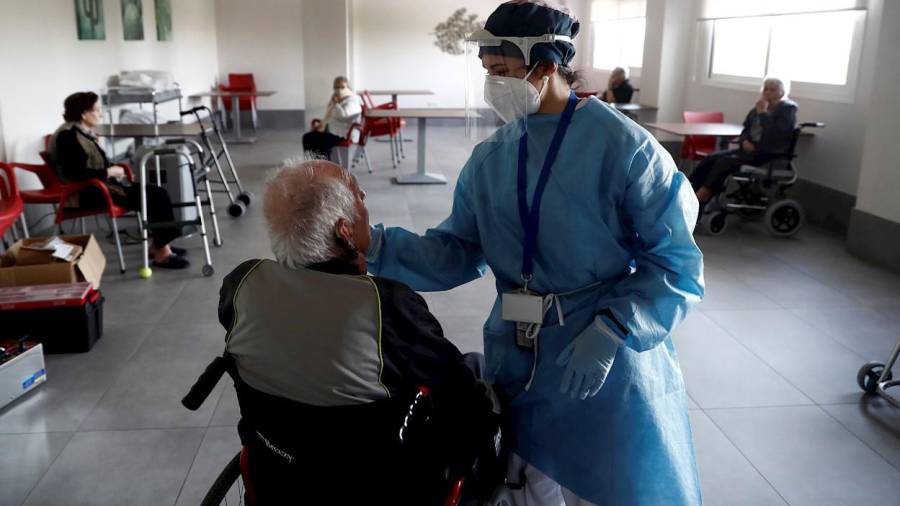 En la foto de archivo, una sanitaria atiende a un anciano alojado en una residencia de Madrid. EFE
