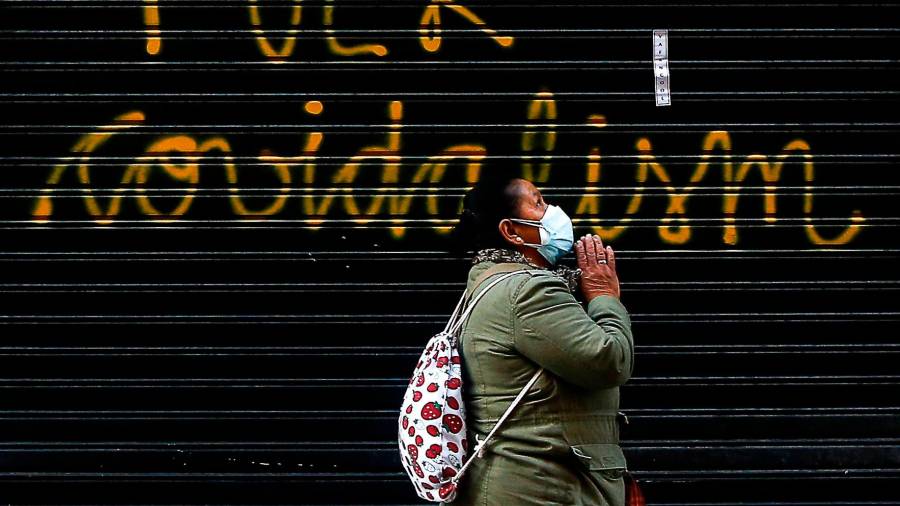 Una mujer pasa ante una pintada en un comercio del centro de Barcelona Foto: Quique García