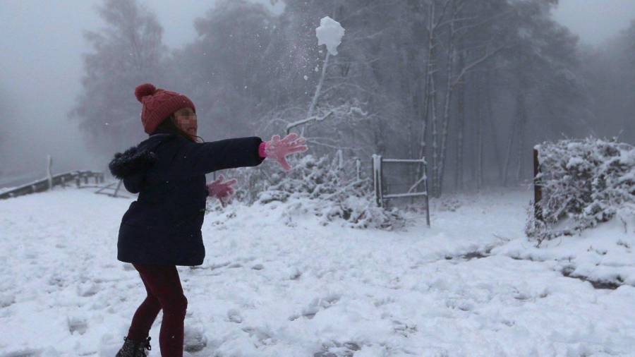Una niña juega con la nieve en A Cañiza. (Autor, Sxenick. Fuente, EFE)