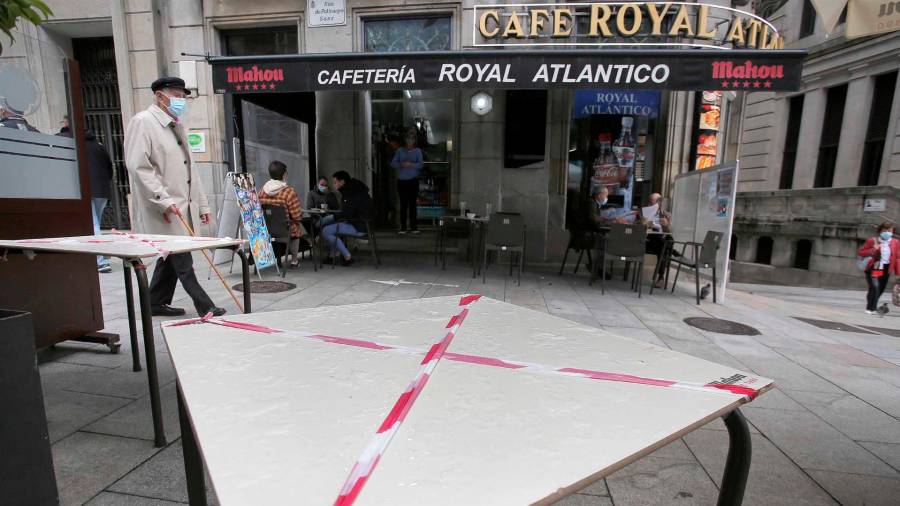 Una mesa de una terraza tachada con una cinta de prohibición en una calle de Vigo