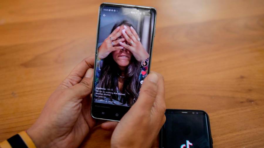 Una persona mira en su móvil el vídeo de una joven en la red musical Tik Tok FOTO: Europa Press
