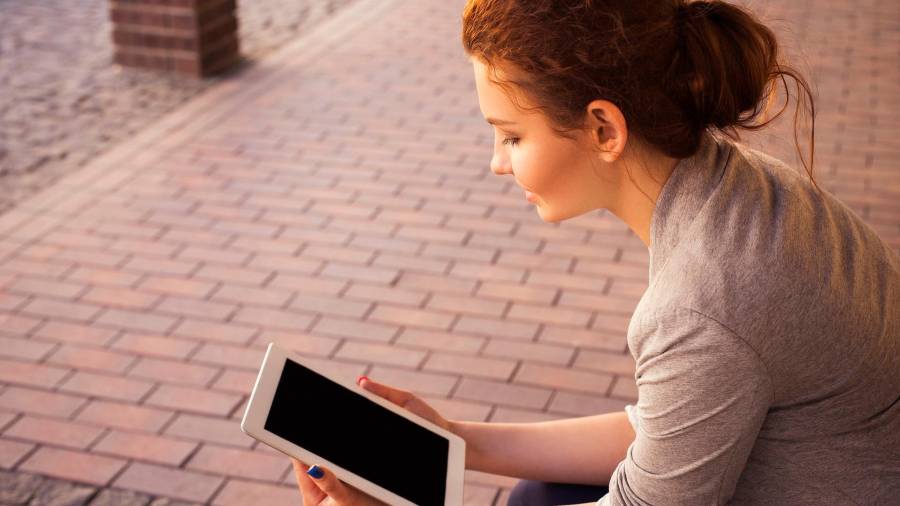 MOCIDADE. Unha rapaza falando por skype cunha tablet na rúa. Foto: qqq.pixabay.com