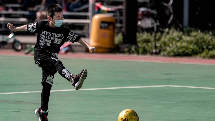 Niño jugando al fútbol con mascarilla en Hong Kong. Foto: E.P.