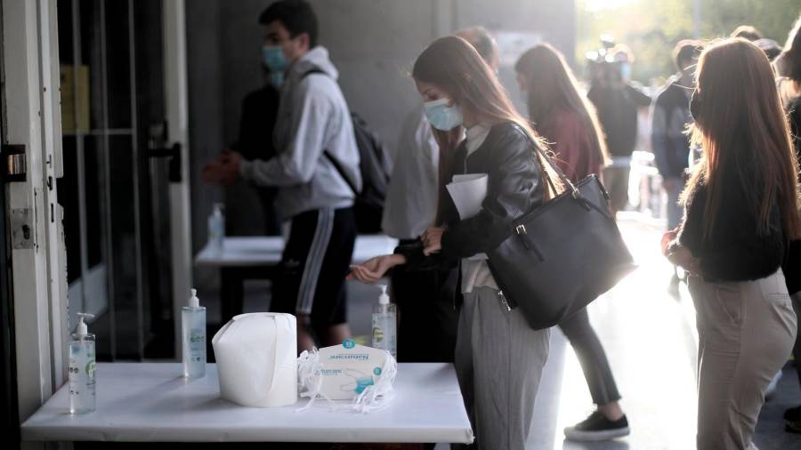 Una alumna se desinfecta las manos antes de entrar al aula de examen de la Facultad de Derecho de la Universidad Complutense. FOTO: Eduardo Parra