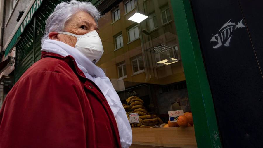 Una mujer protegida con mascarilla se dirige a la entrada de un establecimiento alimenticio en A Coruña. FOTO: M. Dylan