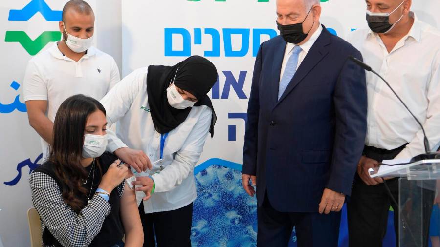 El primer ministro israelí, Benjamin Netanyahu, segundo por la derecha, observa como una dosis de la vacuna contra la COVID-19 Foto: E.P.