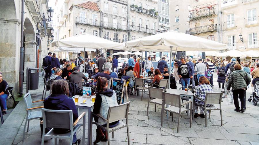 NUEVAS MEDIDAS. Varios grupos de clientes disfrutan en la terraza de un establecimiento hostelero localizado en la ciudad olivica (Vigo). Foto: Marta Vázquez Rodríguez / Archivo