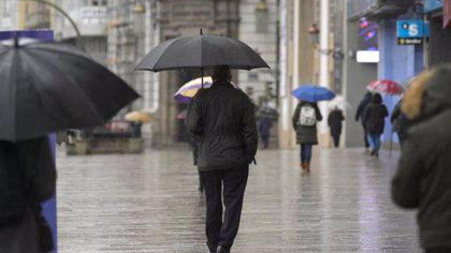 en un día de lluvia Personas caminando con paraguas por una calle de A Coruña. Foto: M.Dylan.