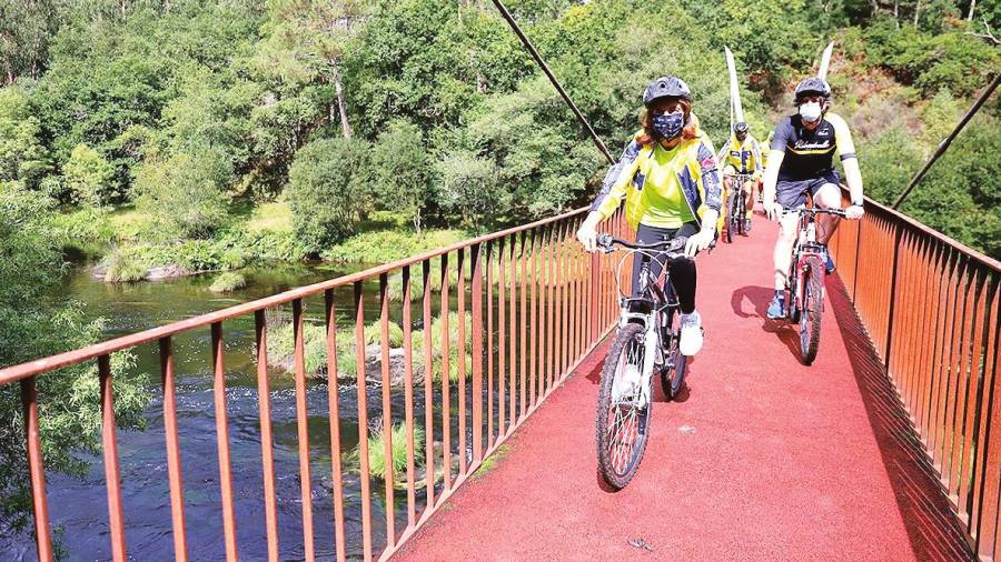 Ángeles Vázquez, en primer término, y detrás el alcalde de Vedra, en el recorrido que hicieron en bici por los enclaves del municipio. Foto: XdG