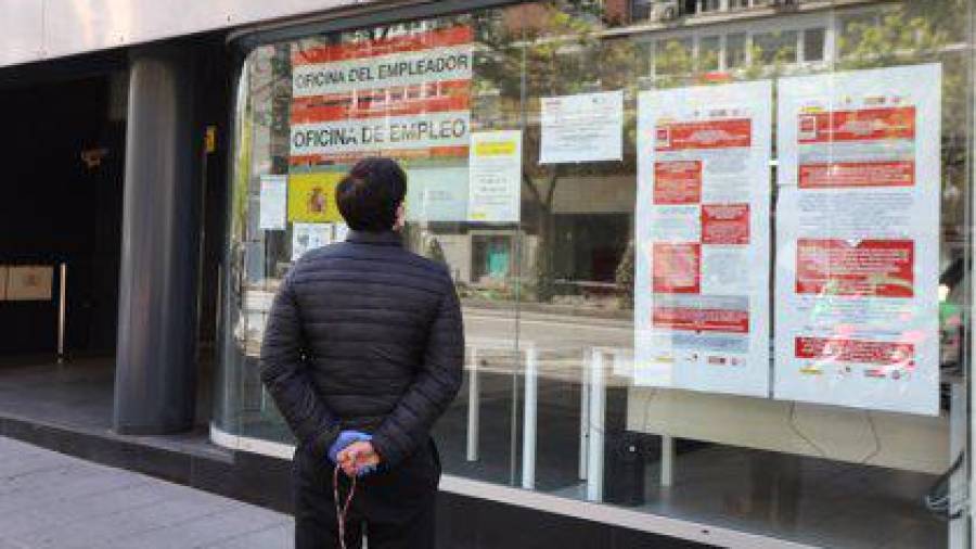 En la imagen de archivo, un hombre se detiene a mirar delante de una oficina de empleo en Madrid. EUROPA PRESS
