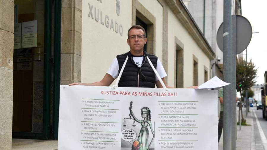 Juan Carlos Varela con la pancarta ante el Juzgado. Foto: Sangiao