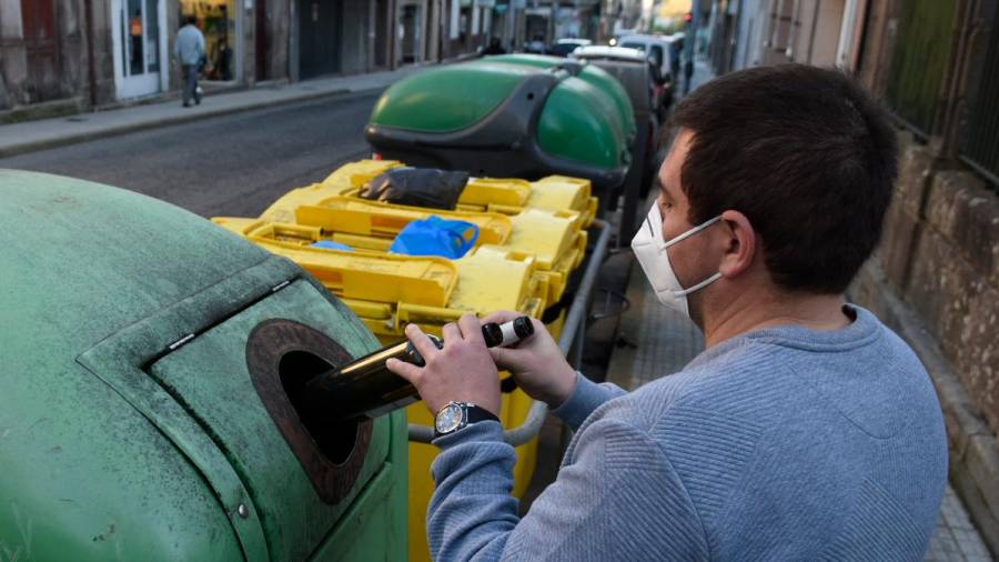 Un veciño da Estrada, municipio cunha alta reciclaxe por persoa, deposita unha botella de vidro no contedor verde. Foto: Puri Sangiao