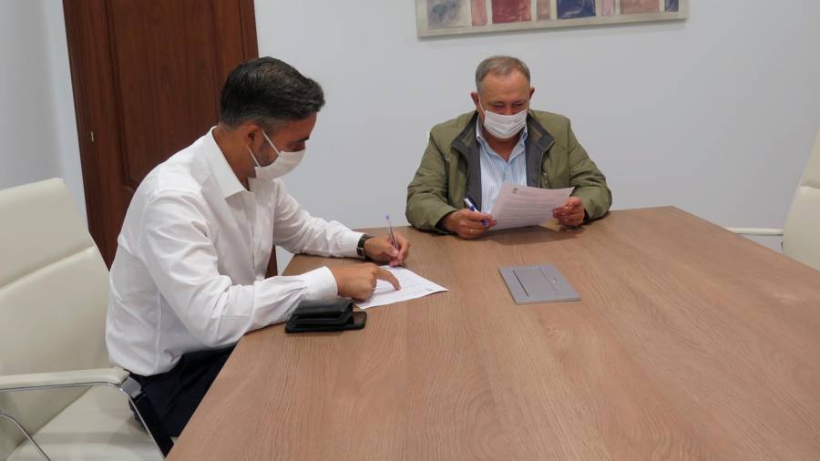 Diego Vázquez, á esquerda, e o alcalde, José Manuel López, asinando o contrato. Foto: Concello da Laracha