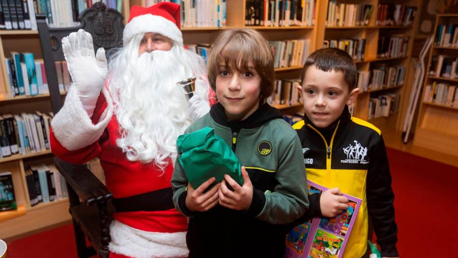 Dous nenos con Papá Noel na biblioteca municipal de Ponteceso. Foto: C. Ponteceso