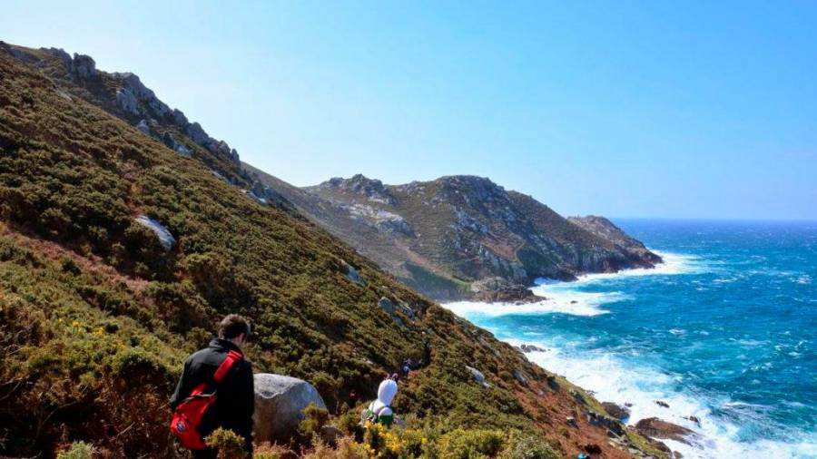 Sendeiristas percorrendo un tramo do Camiño dos Faros polo litoral de Malpica. Foto: O Camiño dos Faros