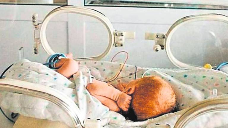 Recién nacido en una incubadora de la unidad de Neonatos del hospital Clínico de Santiago, donde están ingresados los trillizos nacidos el jueves