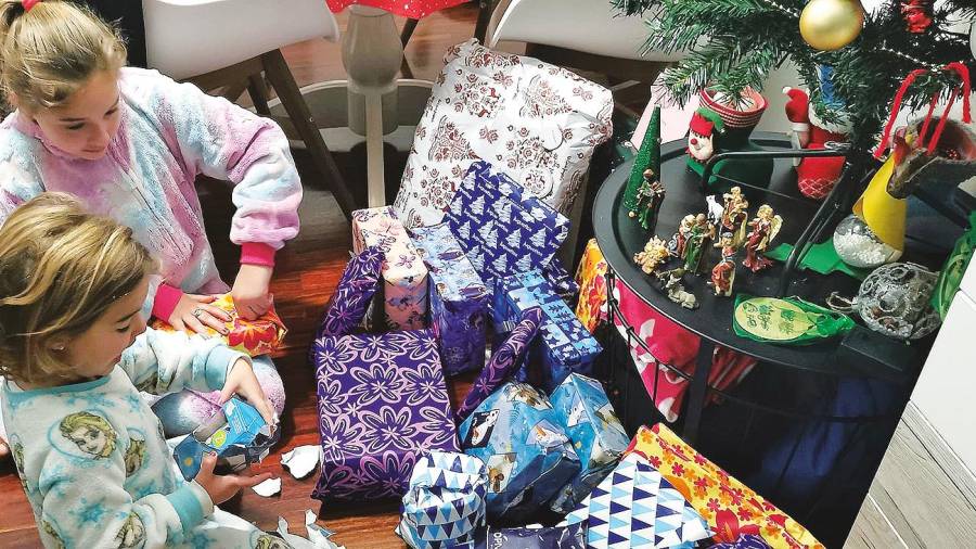 aluvión de regalos. Noa y Luna Carril densenvolviendo sus regalos de Reyes ayer por la mañana