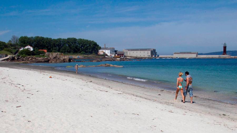 Una pareja paseando ayer por la orilla de la playa de Carril, en Vigo. EFE/ Salvador Sas