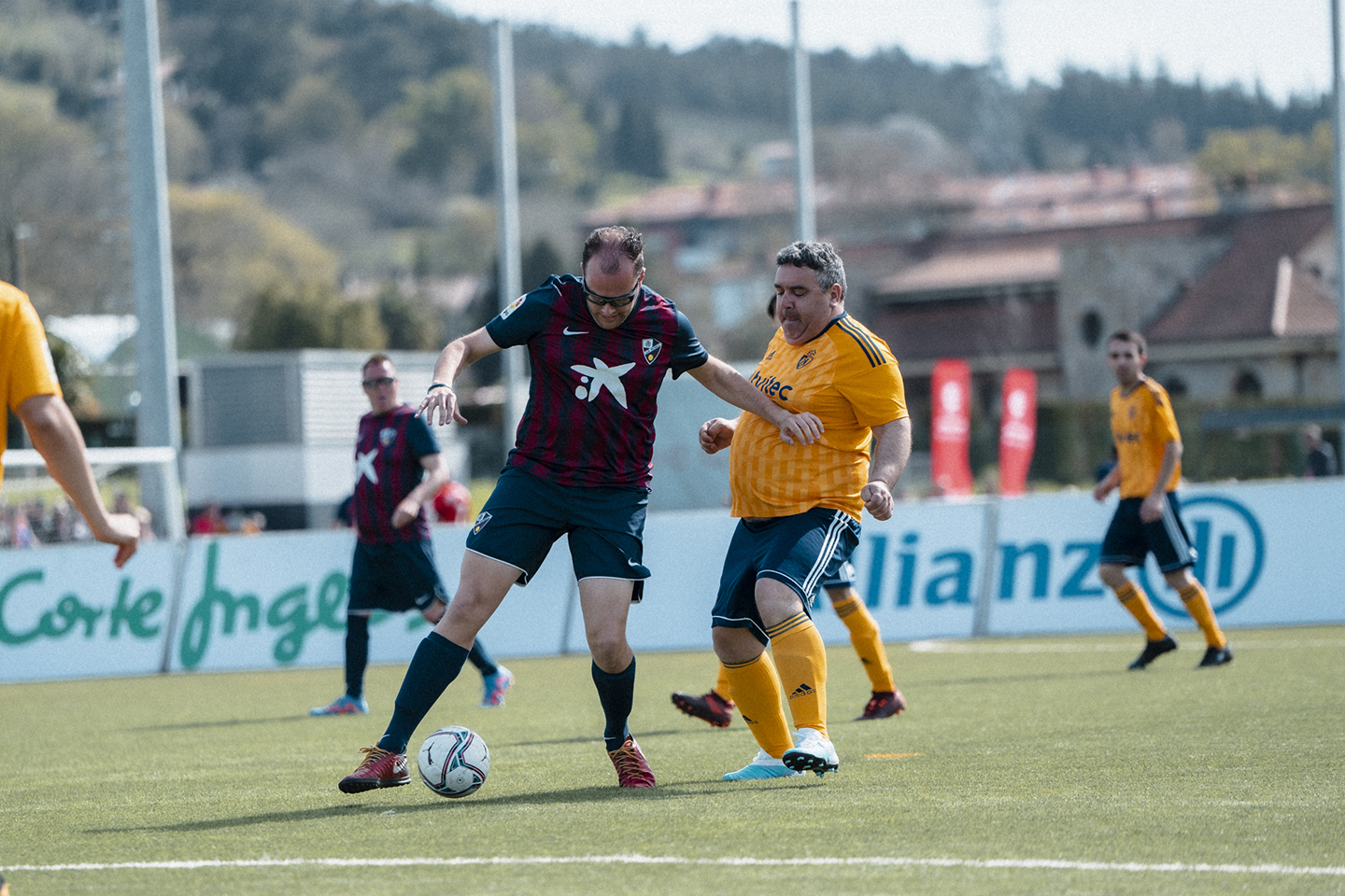 Un jugador de la SD Huesca Genuine protege el balón frente a otro de la SD Ponferradina Genuine en uno de los partidos disputados en la Ciudad Deportiva de Lezama en LaLiga Genuine Santander.